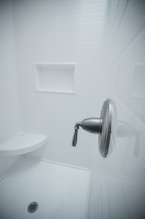 Solid surface shower walls can have textured panels to add character but without grout lines.